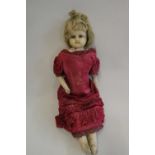 A Victorian wax shoulder head doll, with blue glass eyes, blond hair, closed mouth, kid body and