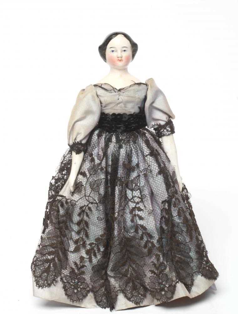 A china shoulder head doll, c.1880, with moulded hair, painted features, fabric body, china lower
