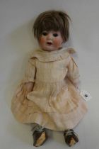 A C.M. Bergmann bisque socket head character doll, with brown glass sleeping eyes, open mouth,