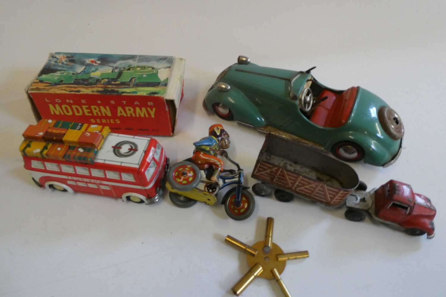 Tinplate toys comprising Disler clockwork saloon, Goso cattle truck, US Zone cycling clockwork