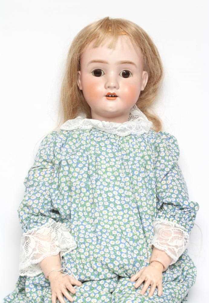 A large Schoenau & Hoffmeister bisque socket head doll, with brown glass sleeping eyes, oepn