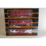 Three bogie coaches of German railway type finished in red, boxed, good to excellent