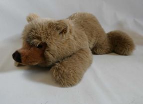 A large Steiff recumbent teddy bear, with long light brown plush, ear button and label, 27" long