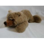 A large Steiff recumbent teddy bear, with long light brown plush, ear button and label, 27" long