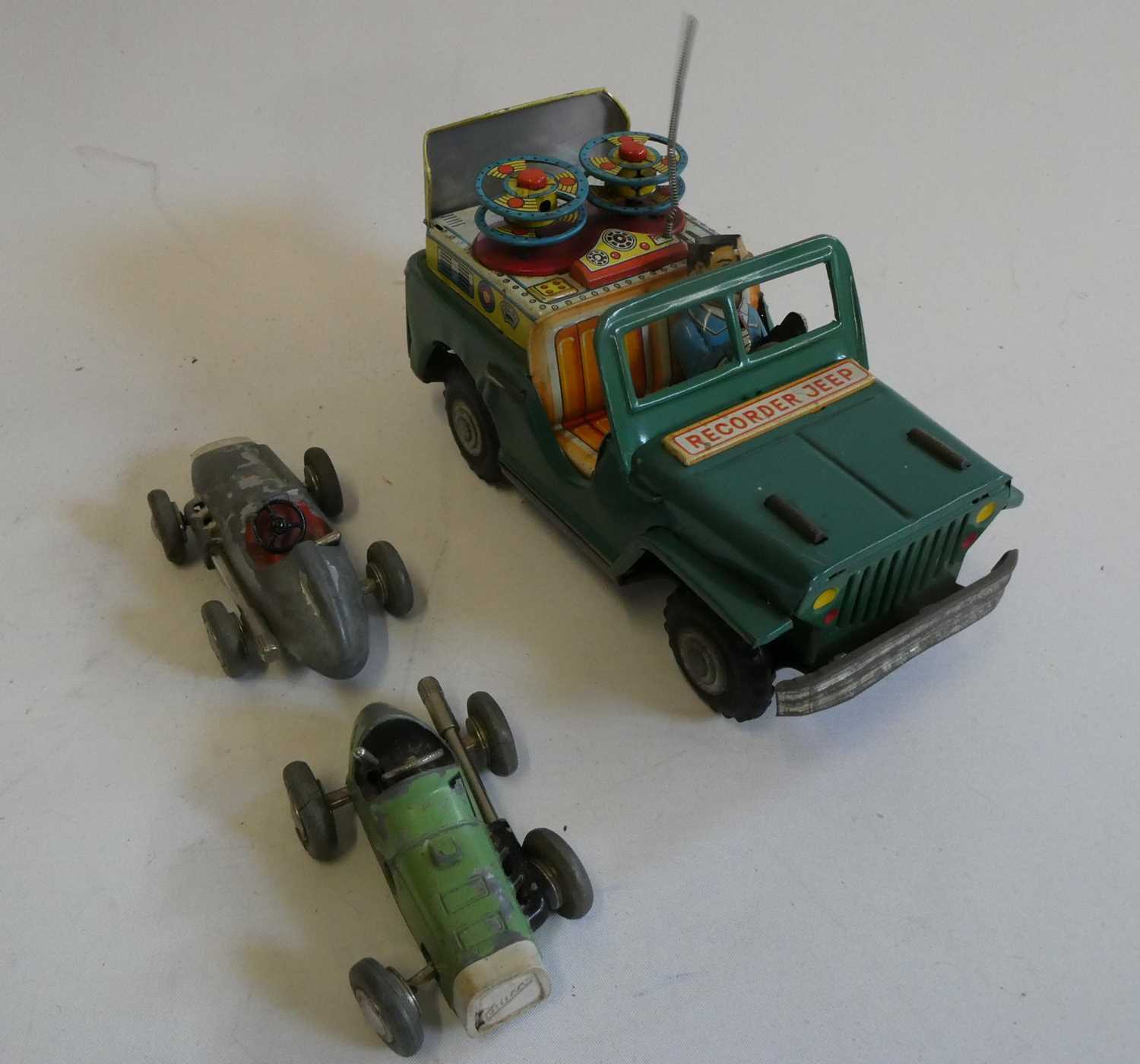 Tinplate friction powered recorder Jeep, driver’s hat is missing, and two Schuco Micro Races,