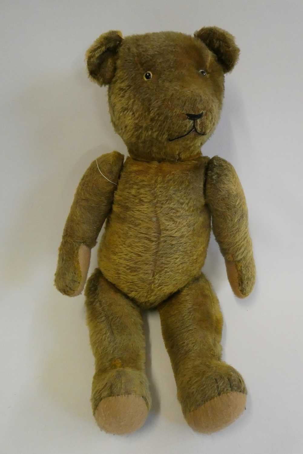 Pre-war jointed teddy bear, with clear glass eyes, orange plush sewn nose and felt pads, 26" long