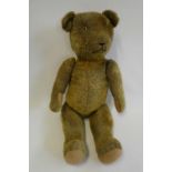 Pre-war jointed teddy bear, with clear glass eyes, orange plush sewn nose and felt pads, 26" long