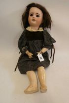 An SFBJ bisque socket head doll, with brown glass sleeping eyes, open mouth, teeth, brown wig,