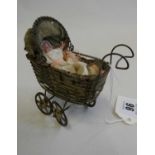 A pre-war filigree dolls house pram, with fabric hood and liner, 4 1/2" long, together with a