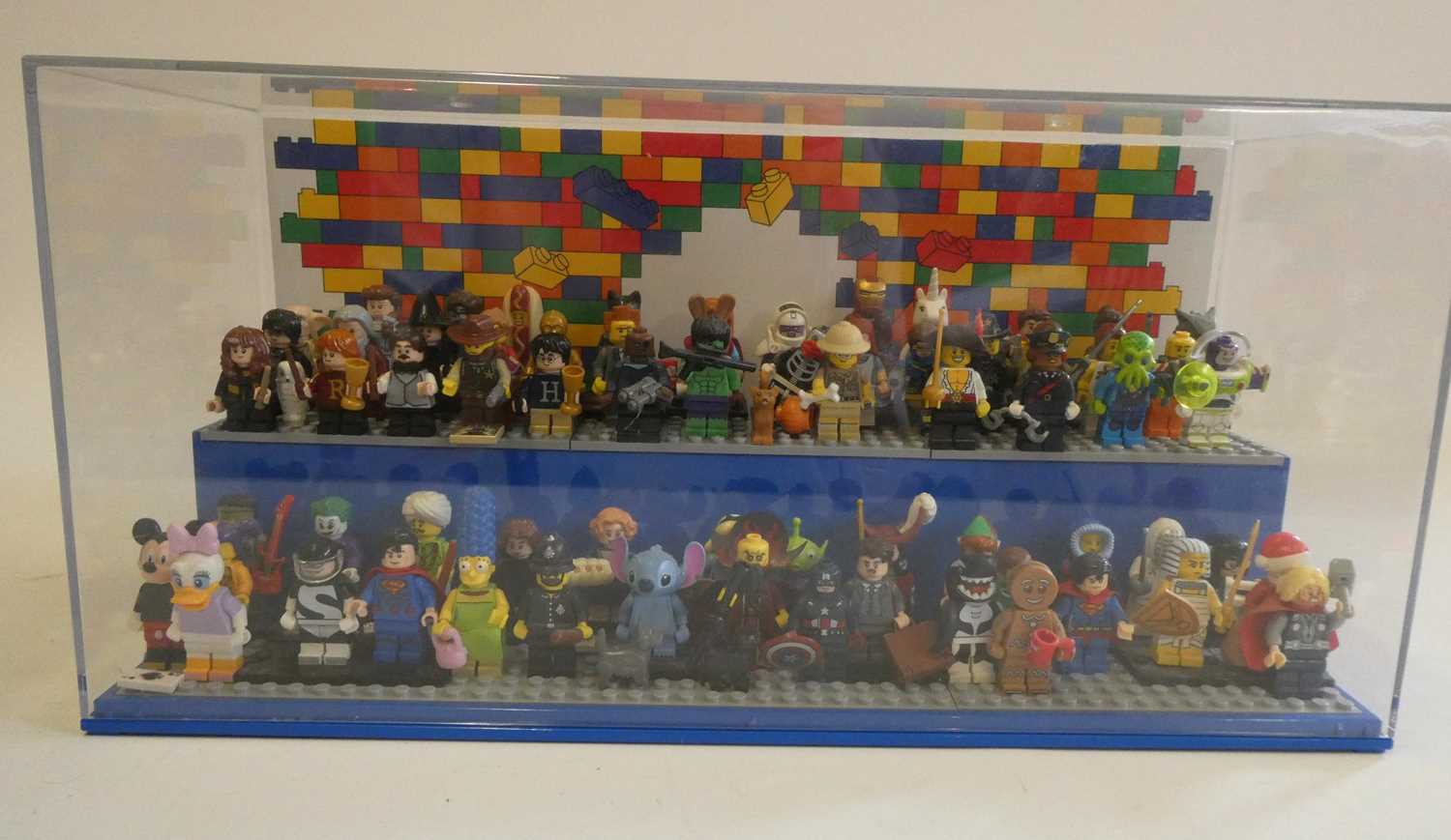 A perspex display case of Lego figures, comprising 68 characters, 3 cats, an owl and a penguin,