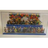 A perspex display case of Lego figures, comprising 68 characters, 3 cats, an owl and a penguin,