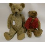 Two old straw filled teddies, comprising a 20" vintage English bear with shaven muzzle, amber eyes