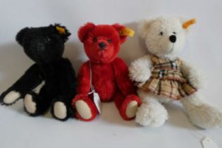 Three Steiff teddy bears including red and black bears with magnetic (interchangeable) joints, and a