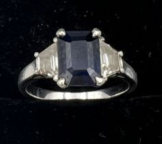 An emerald cut sapphire and baguette diamond ring, set in platinum. Size L. Weight 5gm.