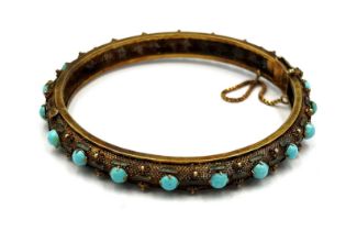 A Chinese 14 carat yellow gold bangle set with turquoise and enamel. 7cm diameter. Weight 22.2gm.