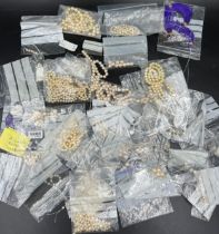 A box of various cultured pearl necklaces and loose beads, most in need of re threading.