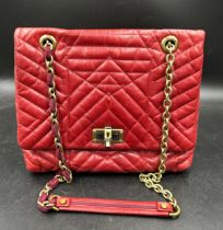 A red leather Lanvin quilted handbag with brass coloured chain, fabric and leather strap, clasp to
