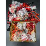 A boxed lot of various red and black coloured glass beads.