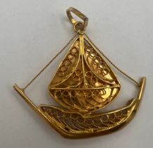 An 18 carat yellow gold filigree sailboat charm. Weight 5.5gm.