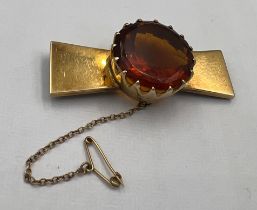 A 9 carat gold brooch with safety chain set with cairngorm Approximately 6cm l. Total weight 24gm.