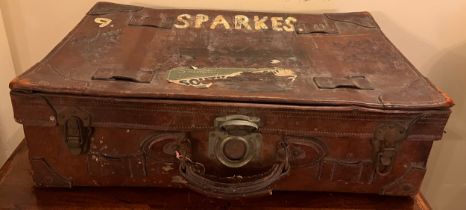 A vintage leather suitcase with paper labels. 65cm x 38cm x 20cm h.