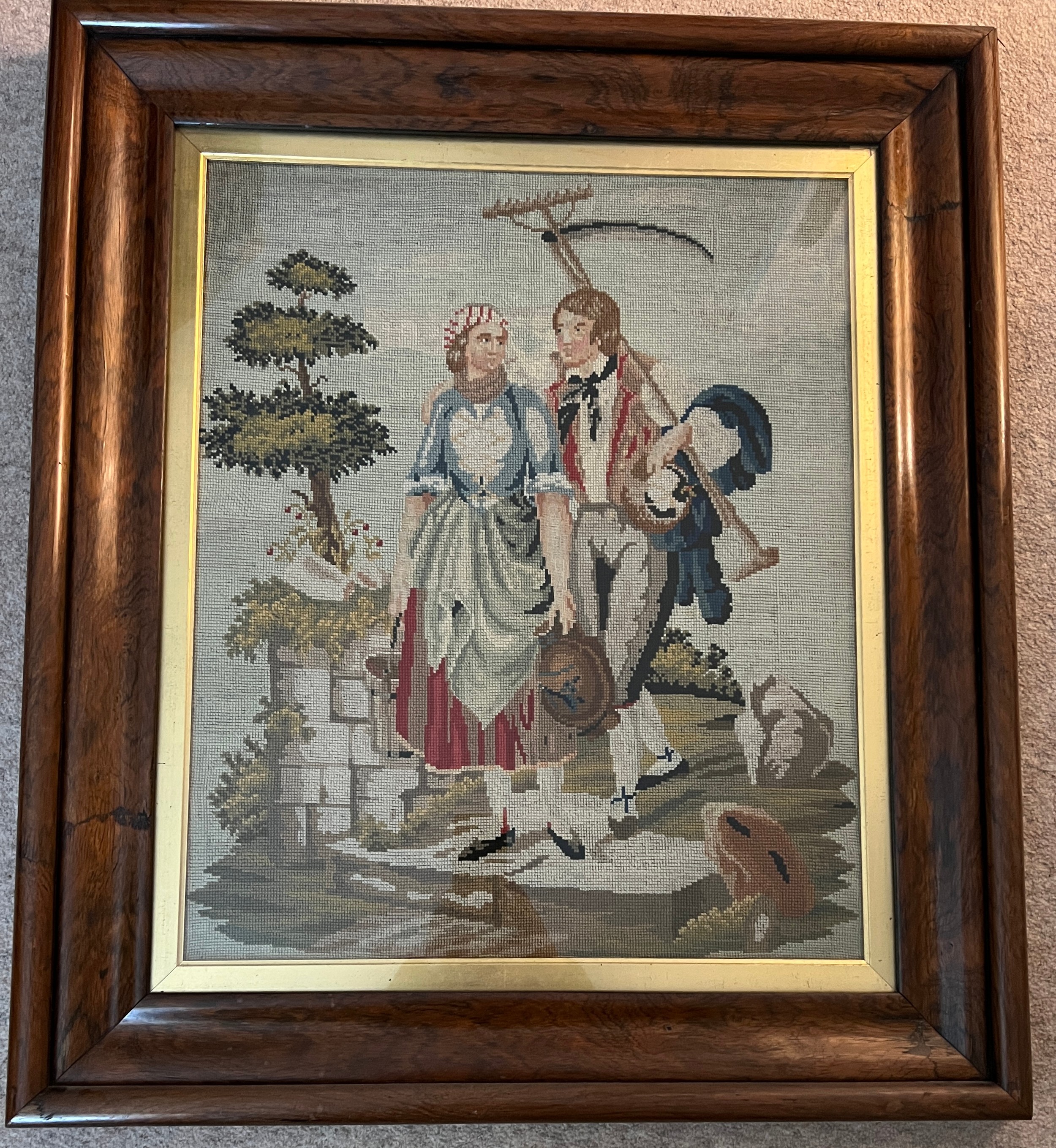 A 19thC woolwork picture depicting a young couple returning from their labours in the field within a - Image 2 of 2