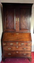 An 18thC mahogany bureau bookcase with candle slides and original brass furnishings. 204cm h x 102cm