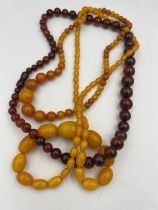 Three strings of amber coloured bead necklaces.