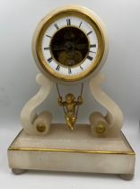 A 19thC French white alabaster cherub on a swing clock. 25cm h. With key.