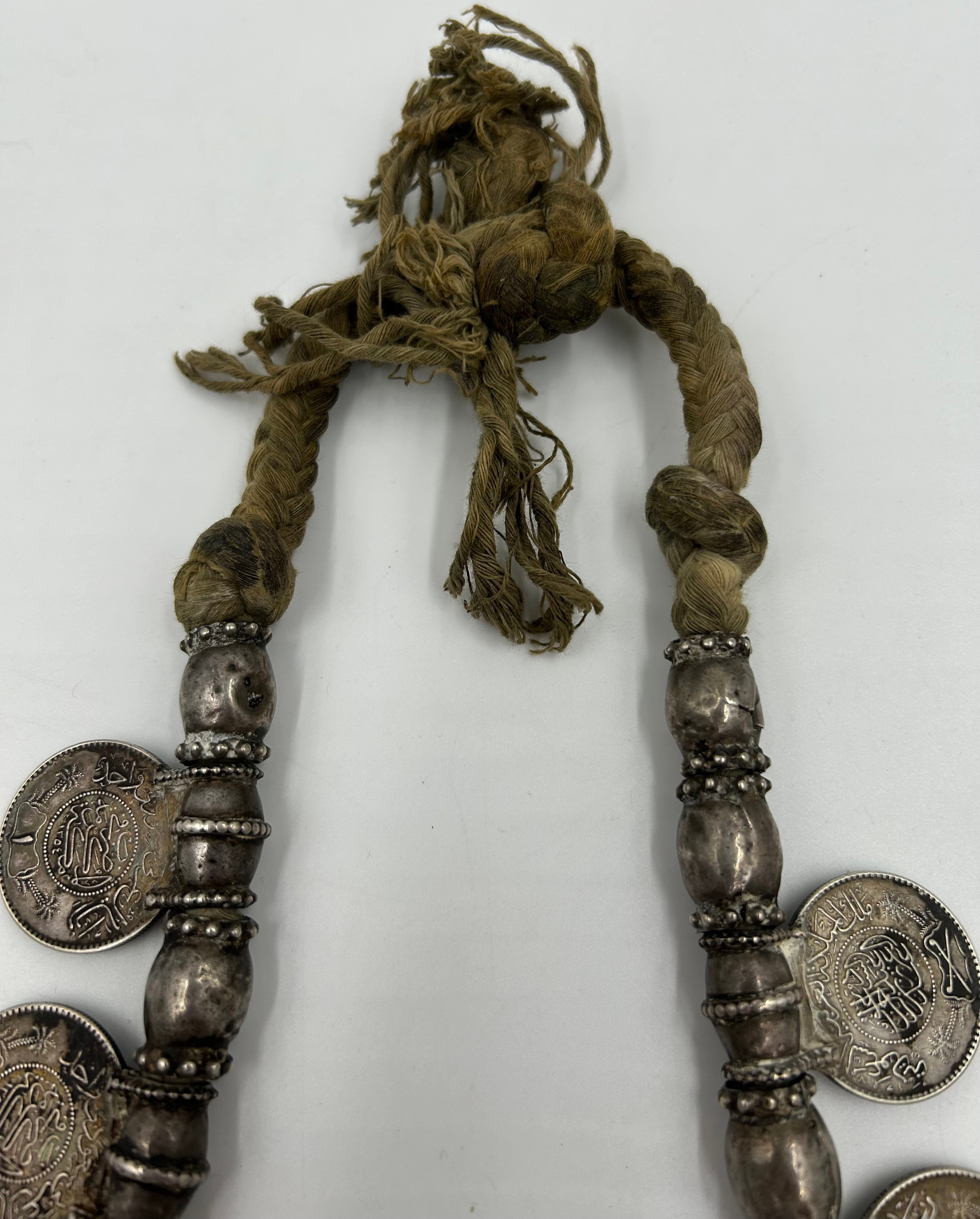 An Omani white metal Hirtz necklace with coin decoration and pendants. 43cm l approx. - Bild 3 aus 7