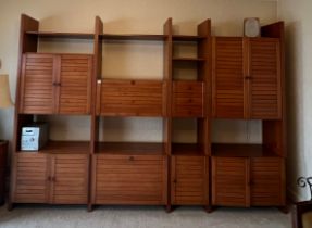 A mid 20thC modular teak bookcase with seven cupboards and three small drawers. 299cm w x 211cm h