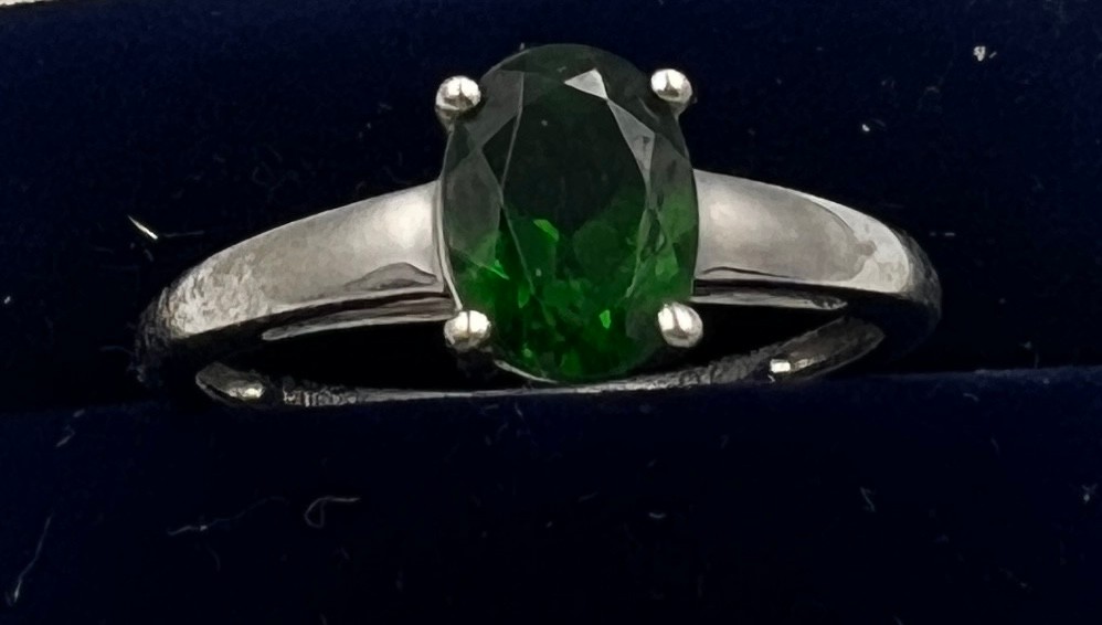 A 9 carat white gold ring set with green stone. Size Q. Weight 2.2gm.