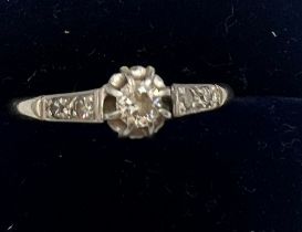 An 18 carat gold and platinum ring set with central diamond and two further diamonds to each side.