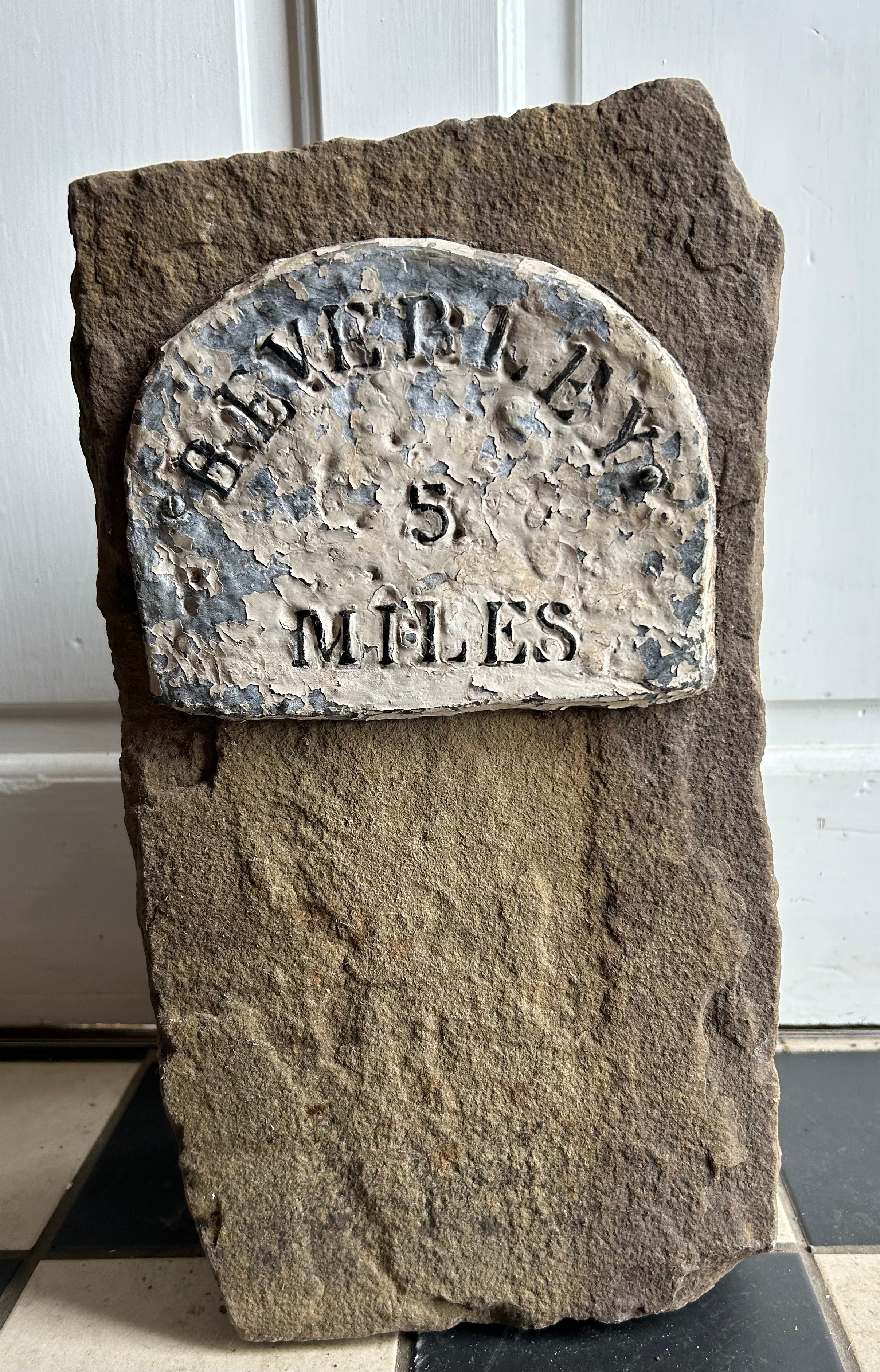 A piece of stone with sign depicting ' Beverley 5 miles'. 39cm h x 21cm w x 16cm d.