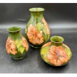 A collection of Moorcroft Hibiscus pattern vases, largest 20cm h, two with signatures and