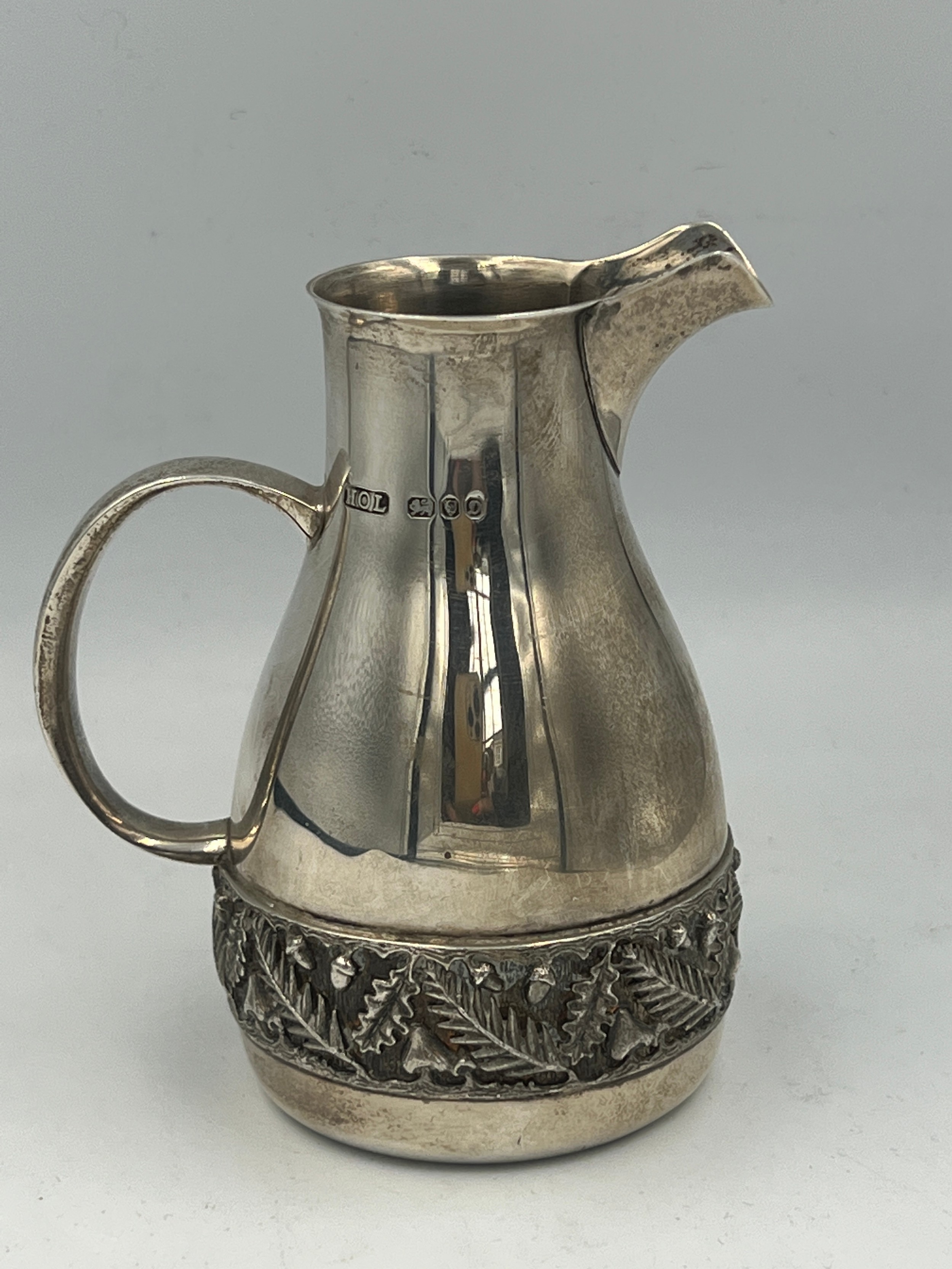 A hallmarked silver jug with acorn and leaf decorative band to base. London 1978, maker House of - Image 2 of 3