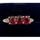 A 9 carat gold ring set with red and clear stones. Size O. Weight 2.2gm.