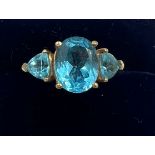 A 9 carat gold ring set with three blue stones. Size N. Weight 3.6gm.