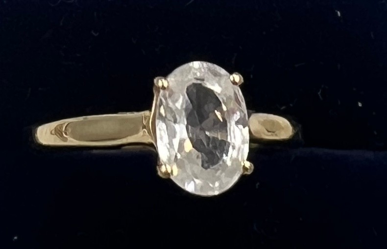 A 9 carat gold ring set with oval white zircon. Size N. Weight 2gm. With certificate of