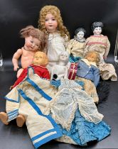 A Victorian doll's dress and cape together with a collection of mainly 19thC dolls to include a