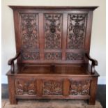 Carved Oak High Back Settle with lift up seat. 133cm wide x 46cm depth x 148cm high.