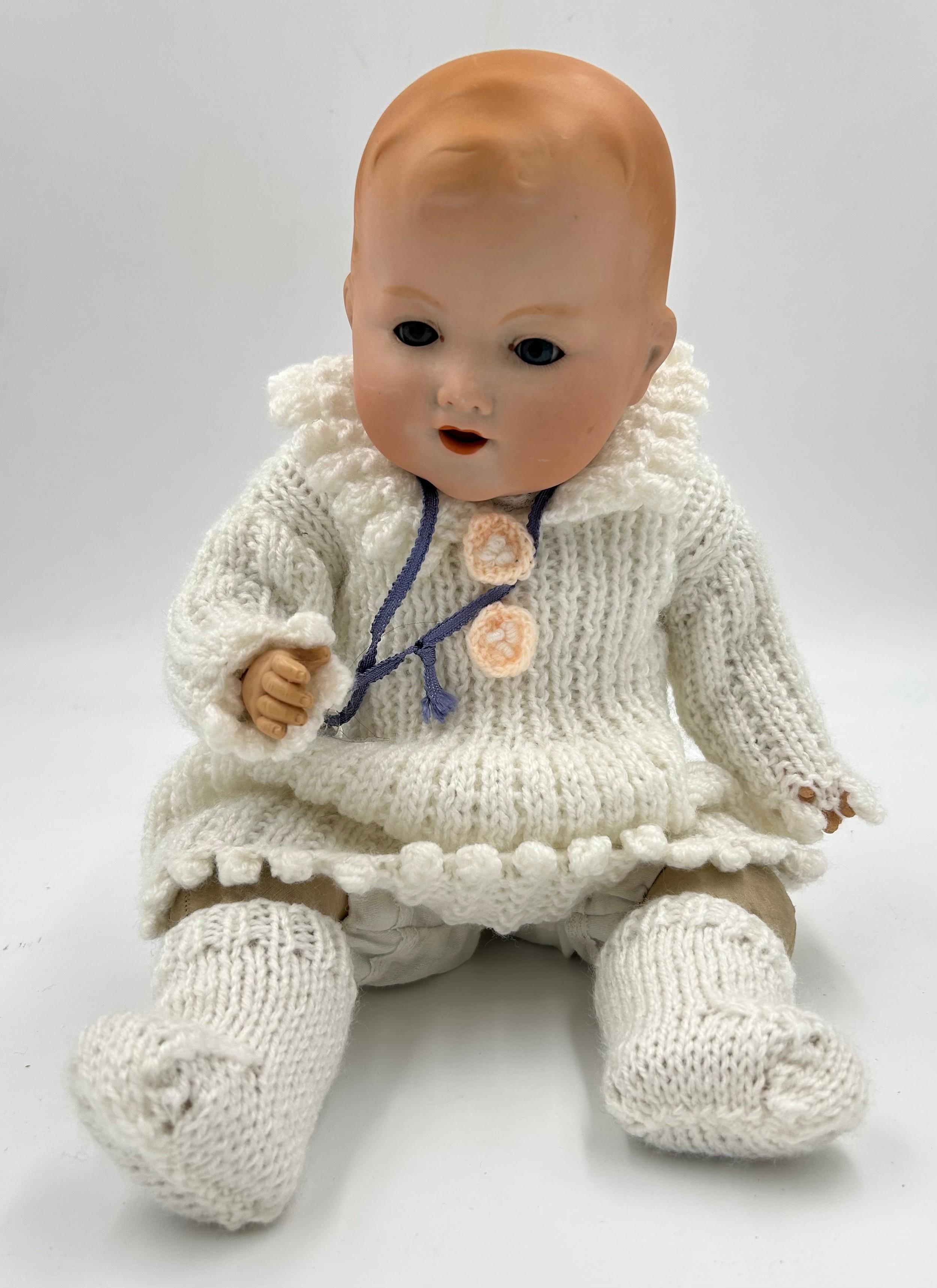 A German Armand Marseille Bisque headed Baby Doll (353/4) with knitted outer clothing and original