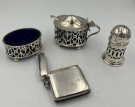 A three piece silver cruet with blue glass liners Birmingham 1900/1919, a plated mustard spoon and a