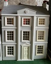 A modern dolls house, 61cm w x 83cm h x 31cm w together with bakers shop, music room, shop with