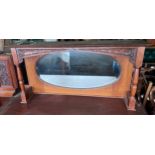 An oak framed mirror with shelf to top and carved decoration. 106cm w x 22cm d x 53 cm h.