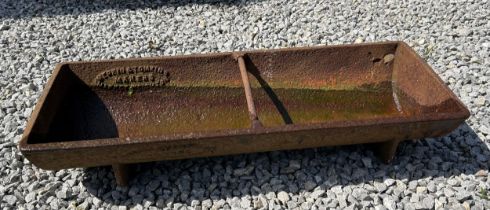 A local vintage cast iron free standing water/food trough. Manufactured by Merkin & Tomkins,