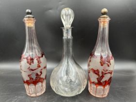 Three etched decanters to include a clear decanter with stopper, cut and etched with thistles with a