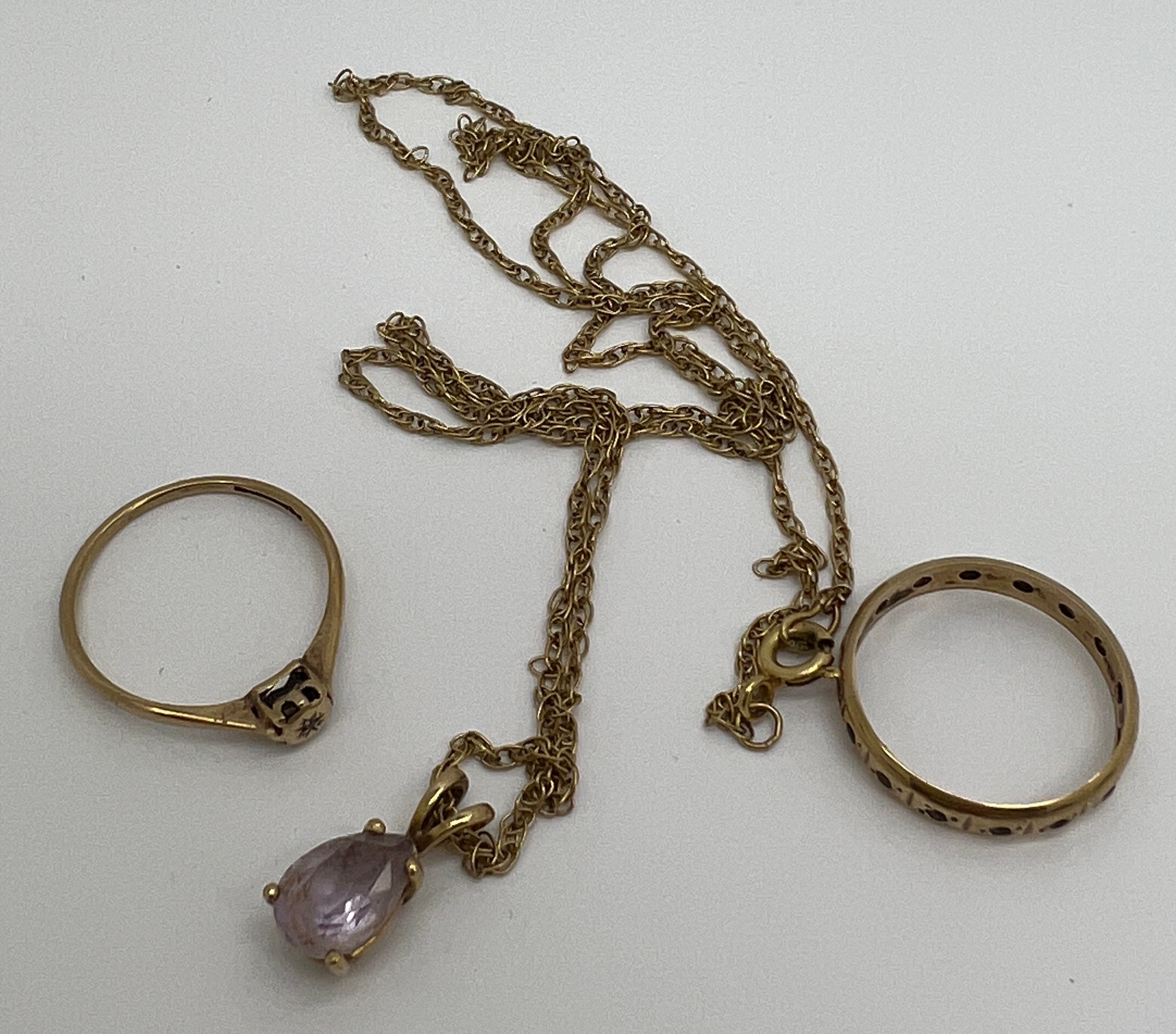 Two 9 carat gold rings and a 9 carat gold chain with unmarked pendant. Total weight 5.1gm.