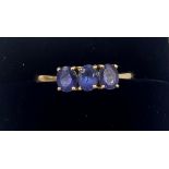 An 18 carat yellow gold ring set with three tanzanites. Size Q. Weight 3gm. With certificate of