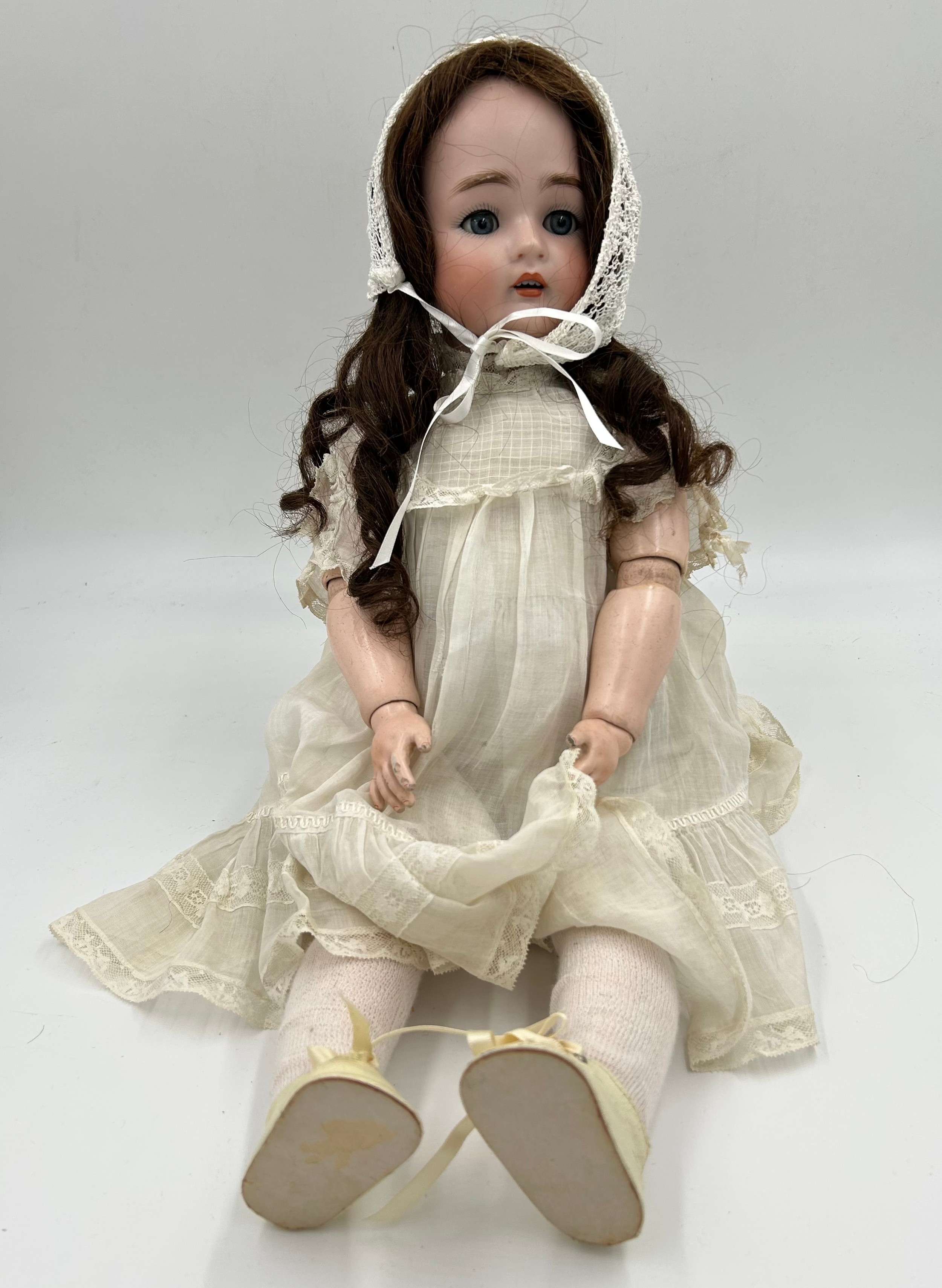 A Simon & Halbig Bisque Porcelain headed doll (57cm) stamp to the neck, with mechanical blue eyes,